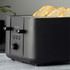 Black 4-slice toaster with slices of toasted bread, angled for feature display