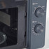 Close-up of grey microwave oven showing open door and control dials for power and timer