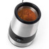 Stainless steel electric spice grinder with ground spices inside, viewed from above