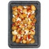 Roast baby potatoes with feta cheese and sliced red chilli on a baking tray