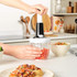 Salter hand press chopper with black lid, stainless steel blade, shown filled with chopped vegetables