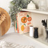 Salt and pepper grinders, one white and one black, on kitchen worktop
