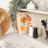 Salt and pepper grinders, one white and one black, on kitchen worktop