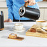 Black 4-slice toaster with wood effect, shown toasting bread in a modern kitchen