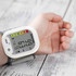 Wrist digital blood pressure monitor on arm, showing results on display