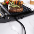 Close-up of black speckled electric grill plate with ridged surface