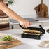 Electric panini press toasting filled baguette in modern kitchen setting