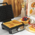 Black square waffle maker with open lid, showing non-stick cooking plates and temperature dial