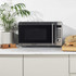 Silver microwave oven, front view, with digital display and control buttons.