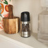 Salter electric pepper mill with black top and stainless steel body on kitchen shelf
