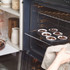 Tray of six chocolate cupcakes being placed in oven