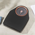 Black digital bathroom scale with textured surface on tiled floor