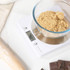 Salter digital kitchen scale weighing baking ingredients: flour, egg, butter and sugar.
