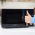 Black Salter microwave with wood-effect handle, hand opening door on a kitchen counter