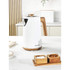 White electric kettle with wood-effect handle and base on kitchen counter