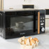 Black Salter microwave with wood-effect handle on kitchen counter, eggs in carton in foreground