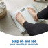 Person standing on white digital bathroom scales showing 60.0kg