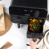 Salter dual air fryer with cupcake batter being spooned into paper cases, top-down view.