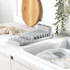 Grey plastic dish rack with cutlery holder on kitchen counter, shown empty.