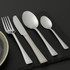 Set of four stainless steel cutlery pieces on wooden table: knife, fork, spoon, teaspoon.