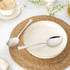 Set of two stainless steel dessert spoons on woven placemat with bowl