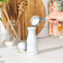 White Salter salt grinder being filled with sea salt in a kitchen setting