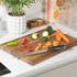 Salter chef’s knife on wooden chopping board with sliced carrot, courgette, and peppers.