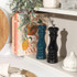 Set of two Salter salt and pepper mills, one dark green, one black, shown on a kitchen shelf.