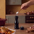 Black wooden pepper mill on kitchen worktop