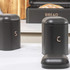 Black kitchen storage tins for salt, coffee, and bread, with metallic lettering.
