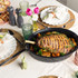 Roast joint in black enamel roasting pan with lid, shown on kitchen worktop