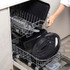 Set of black enamel roasting tins with roast meat and vegetables on kitchen counter
