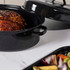 Black enamel roasting pan with lid, shown front view with size dimensions.