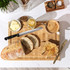 Breakfast setup: sliced rustic bread, butter, honey, and coffee on wooden board