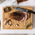 Roast beef joint, sliced on a wooden board with knife, garlic, thyme, and pepper.