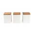 Set of three white storage canisters with natural wood lids, shown front view