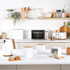 White and wood kitchen appliance set including kettle, toaster, microwave and storage jars on counter