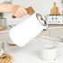 White electric kettle with wood-effect handle on kitchen counter