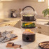 Electric steamer with cooked salmon, vegetables and rice on a kitchen counter