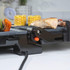 Close-up of electric grill in use with sliced vegetables, corn and grilled chicken.