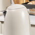 Close-up of cream electric kettle with metallic spout and handle, shown on kitchen counter