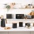Black kitchen appliance set with wood accents, including kettle, toaster, microwave and storage jars.