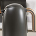 Matte black electric kettle with gold handle, shown on kitchen worktop.