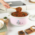 Pink Salter slow cooker with tomato stew, lid being lifted, kitchen counter setting