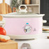 Pink Salter slow cooker with tomato stew, lid being lifted, kitchen counter setting