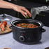 Black Salter slow cooker with chilli being garnished; countertop product listing.