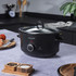 Black Salter slow cooker with side handles, removable glass lid shown beside the unit.