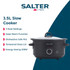 Person using a black Salter slow cooker on a kitchen counter, lid closed, daytime setting