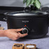 Black electric slow cooker with control dial, shown from front angle