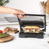 Black electric panini press with open grill plates, shown front-on for product detail